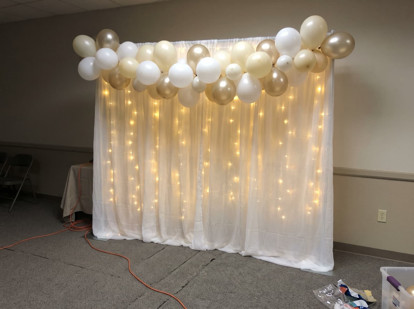 Sheer drape backdrop glowing behind a champagne garland
