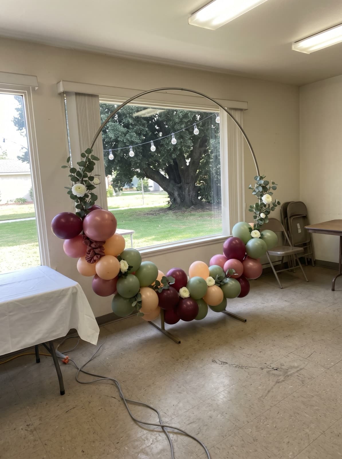 Balloon and floral hoop in front of a big garden window