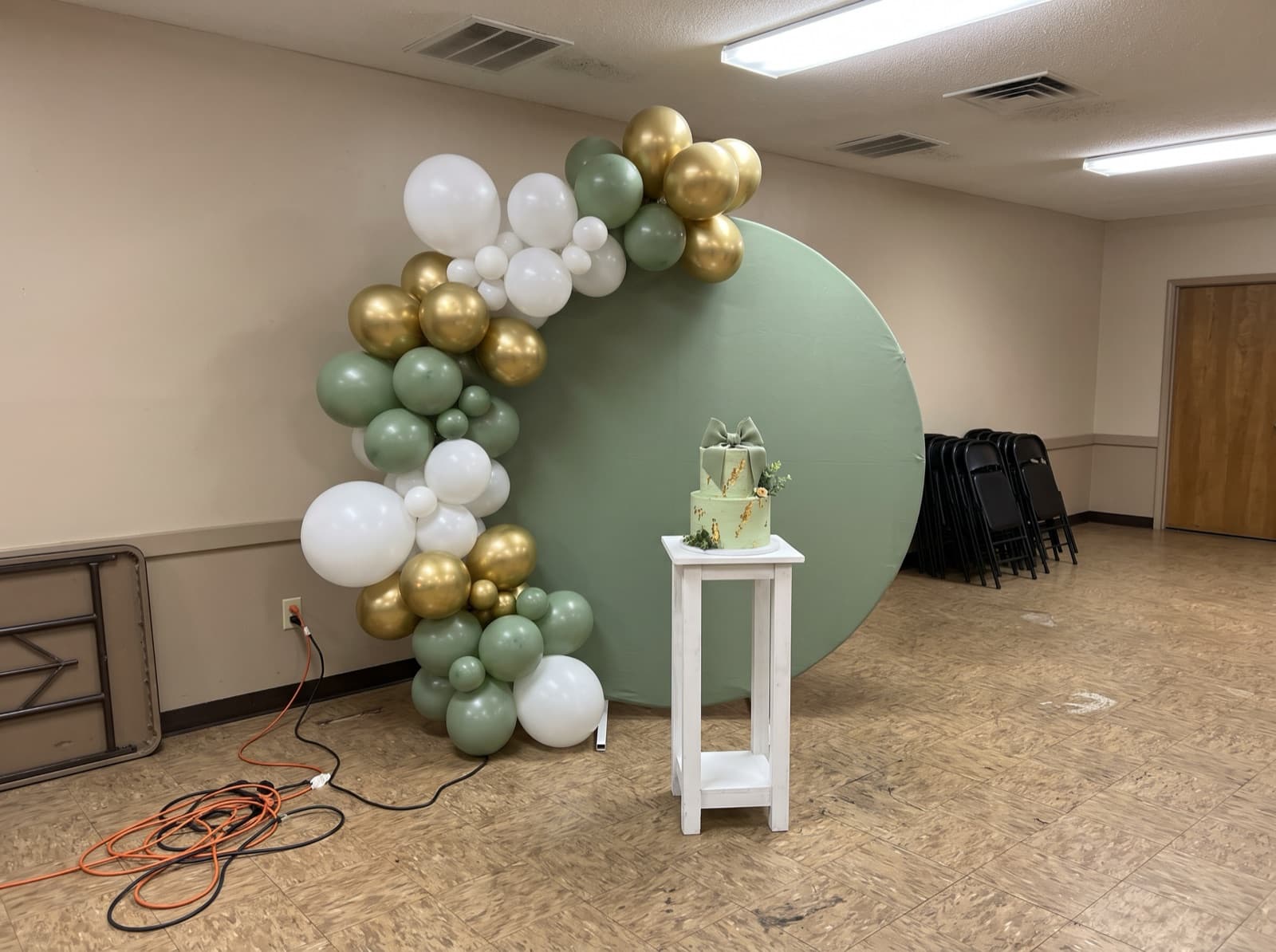 Sage round panel with a white and gold garland