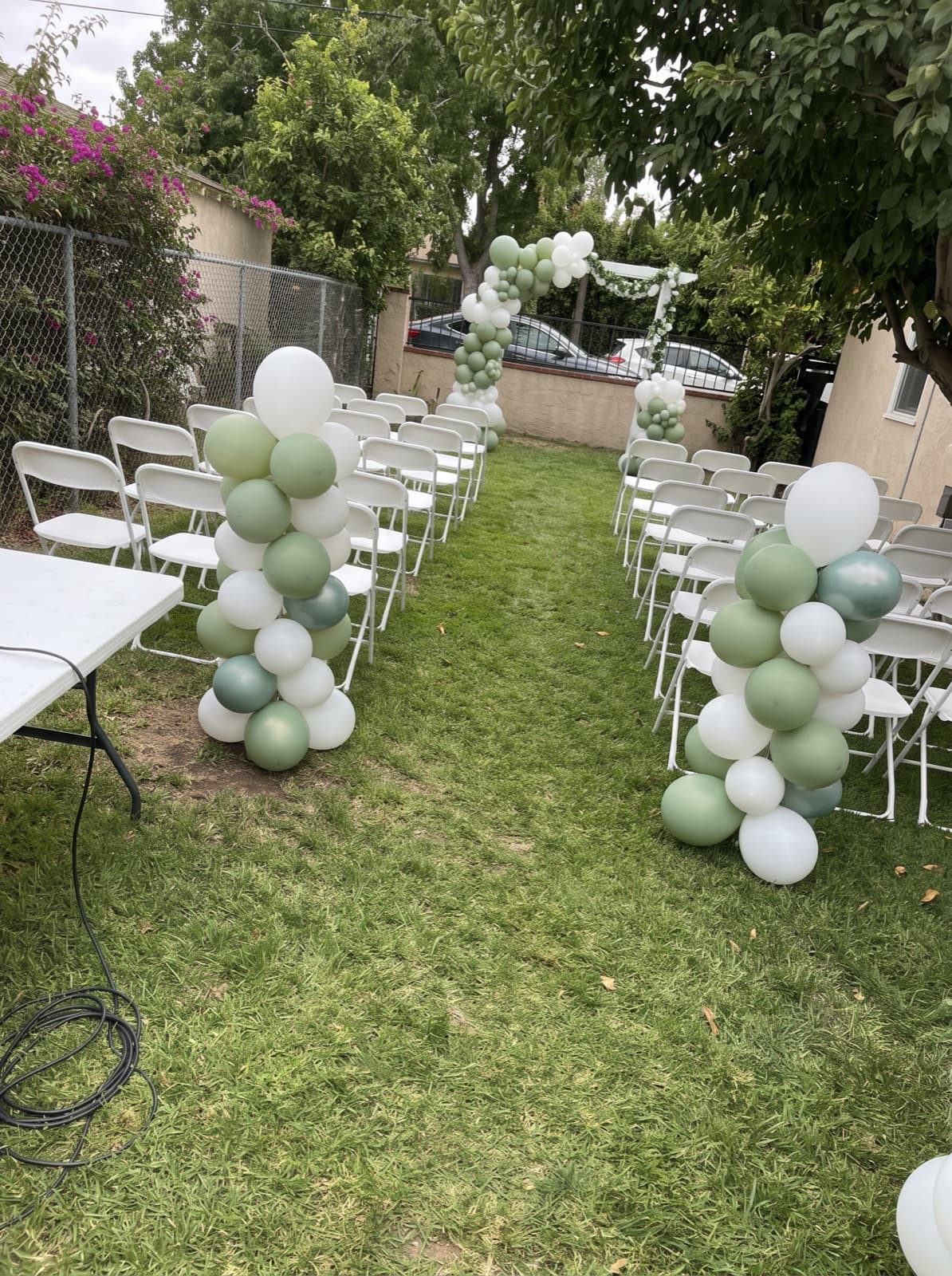 White and sage organic columns along a lawn aisle