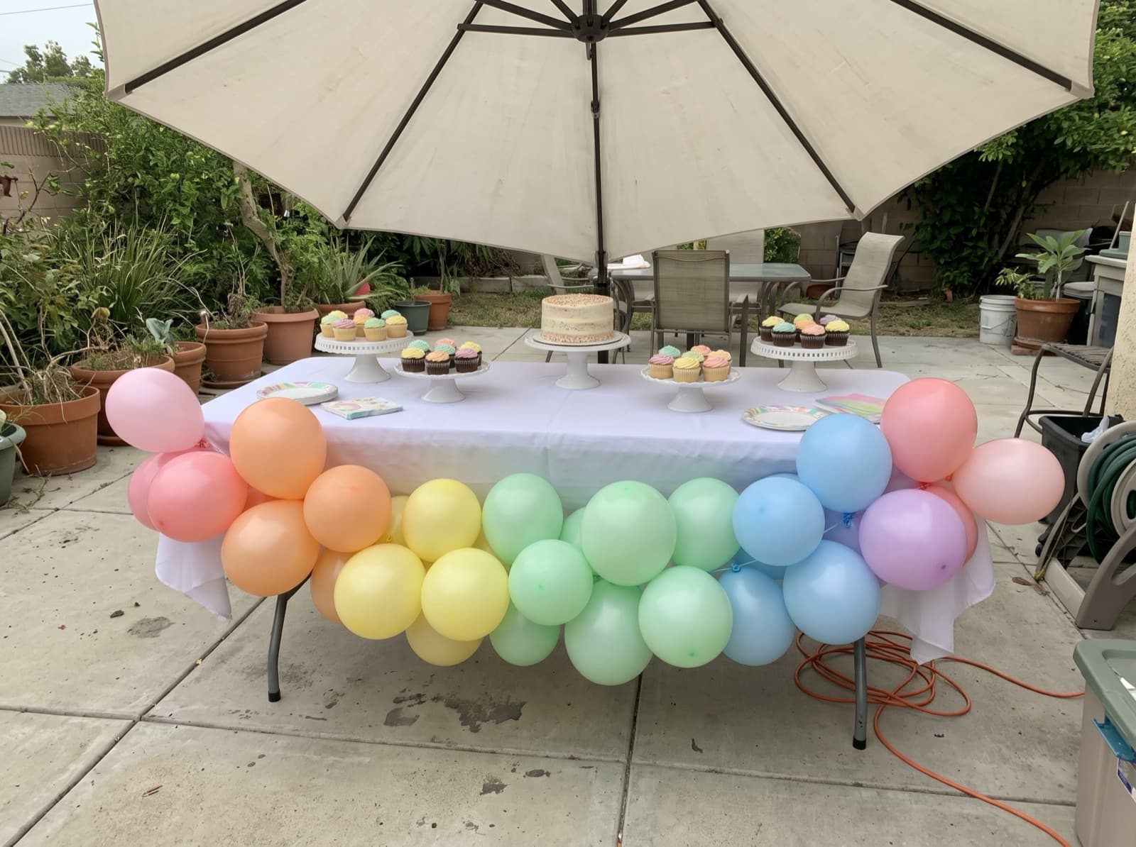 Pastel rainbow garland swagged along a cake table edge