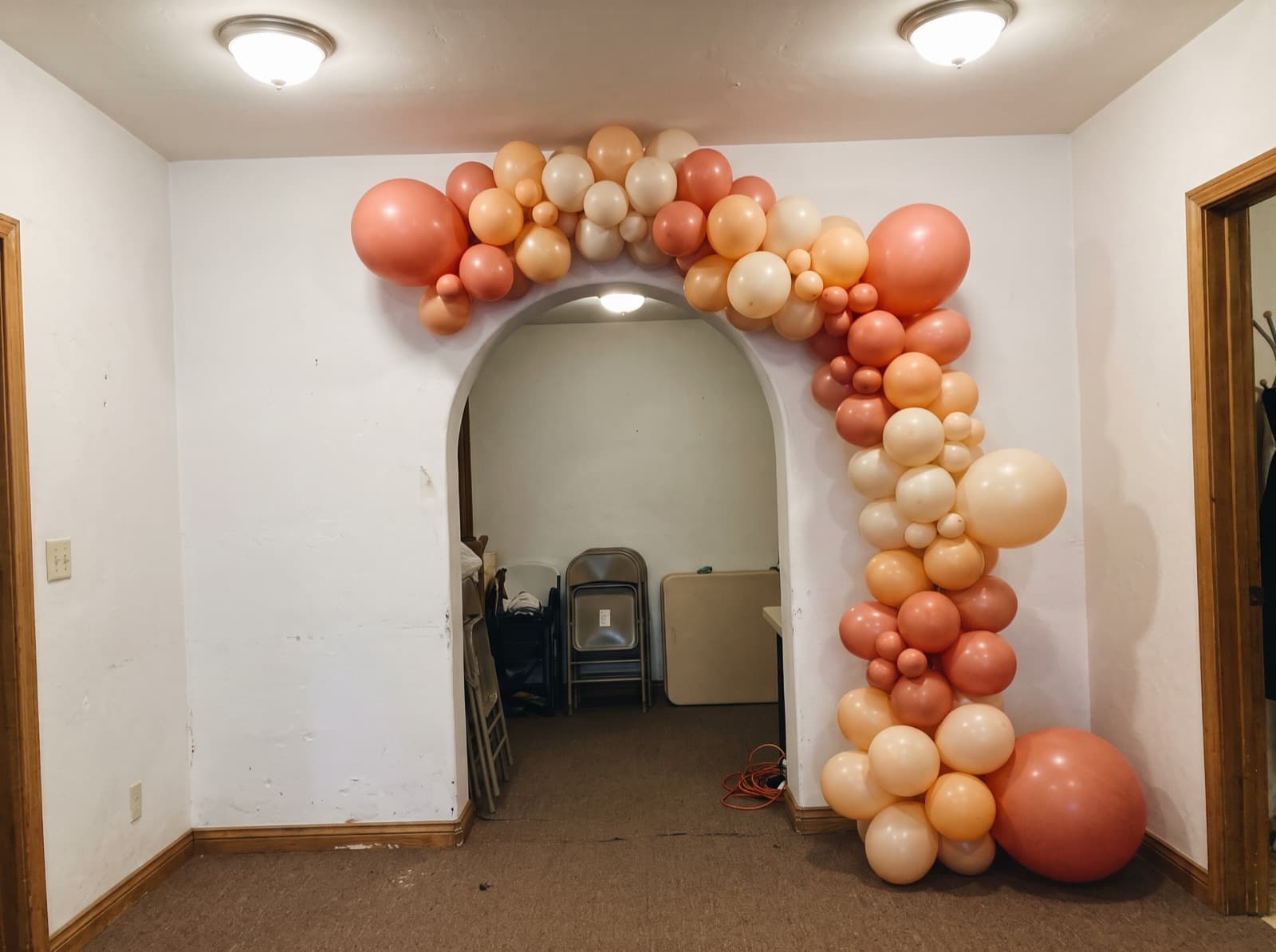 Coral, peach and cream garland around a plaster archway