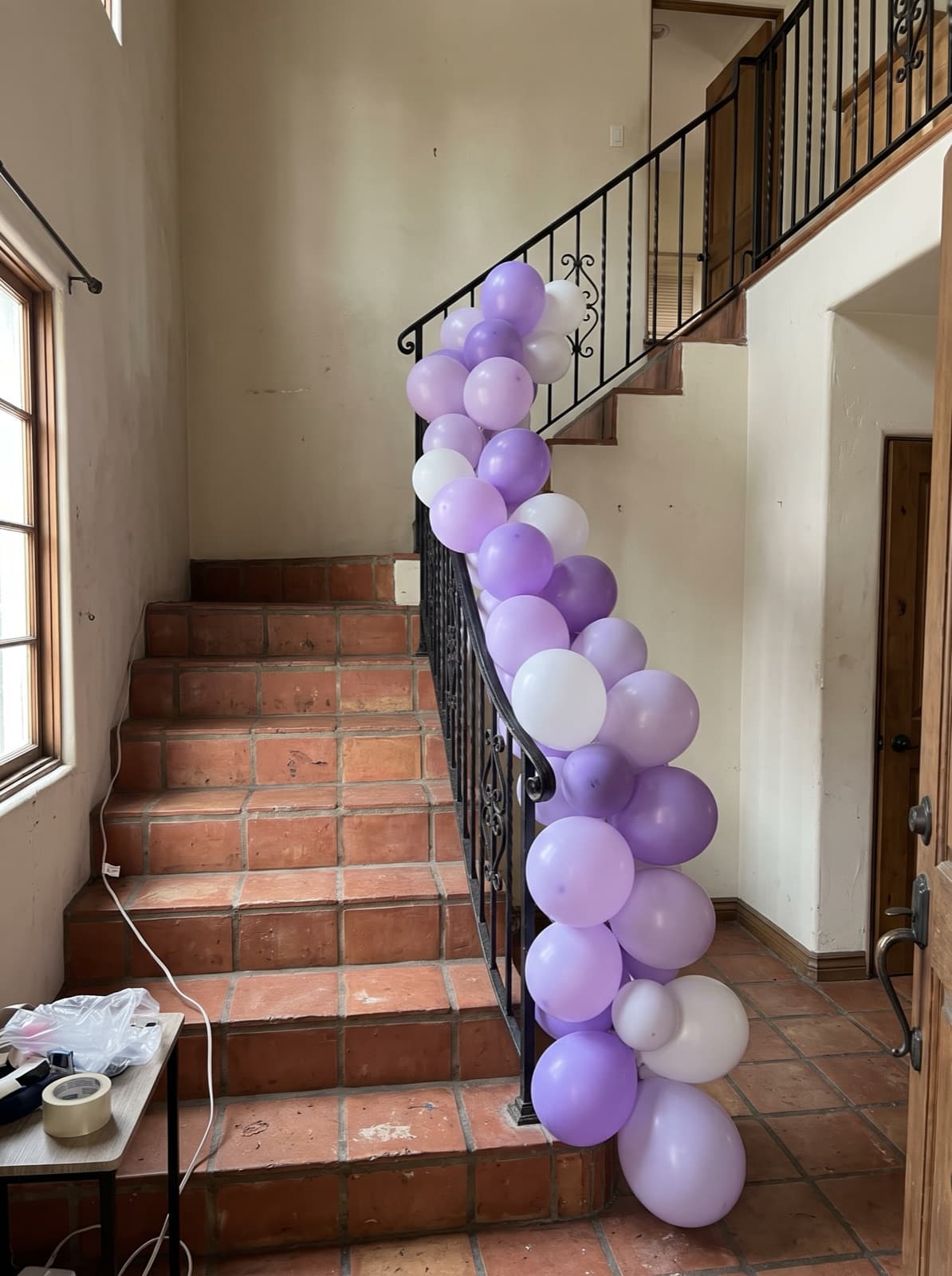 Lilac and white garland trailing a wrought-iron stair rail