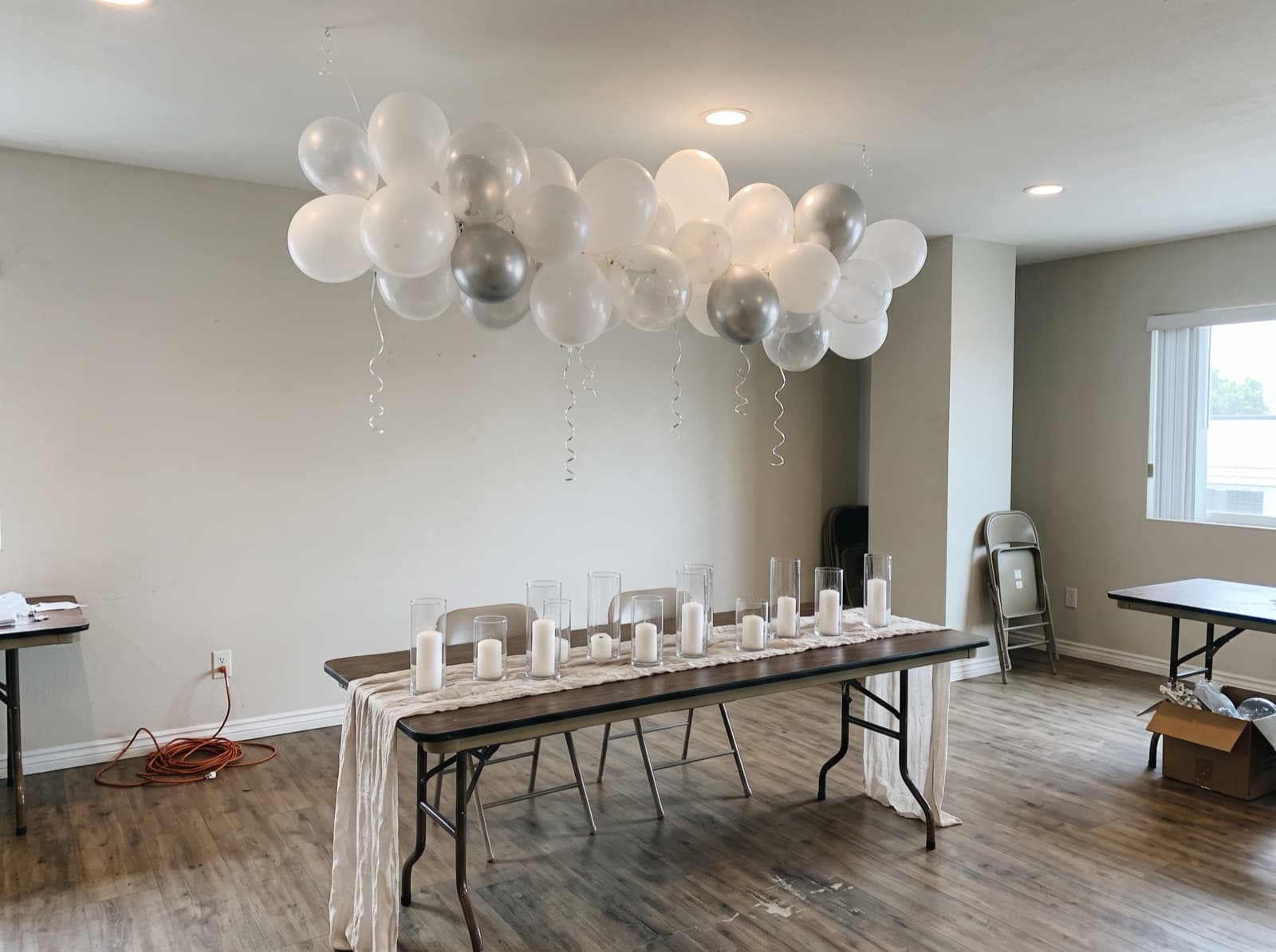 White and clear balloon cloud floating over a long table