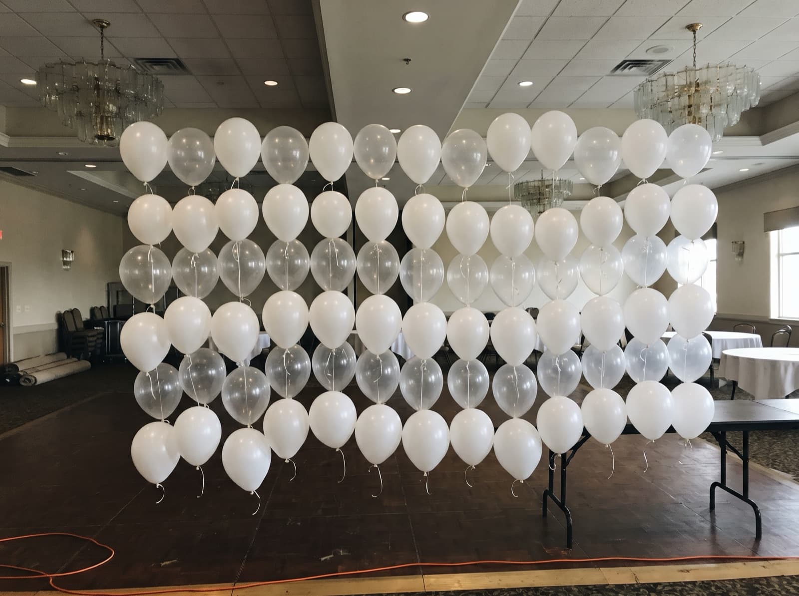 White and clear helium balloons floating in rows